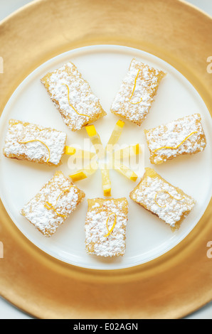 Pikanter süße Zitrone Bars mit Zitrone garnieren und Zucker des Konditors Stockfoto