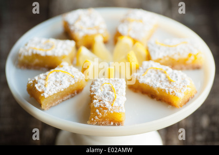 Pikanter süße Zitrone Bars mit Zitrone garnieren und Zucker des Konditors Stockfoto