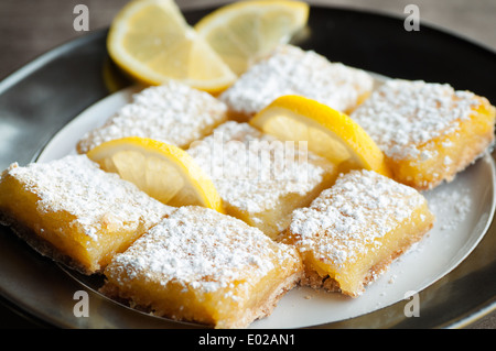 Pikanter süße Zitrone Bars mit Zitrone garnieren und Zucker des Konditors Stockfoto