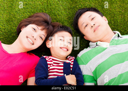 glückliche Eltern und Sohn auf einer Wiese liegend Stockfoto