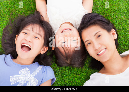 glückliche Mutter und Töchter auf einer Wiese liegend Stockfoto