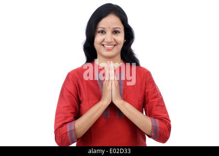 Lächelnde junge Frau Gruß "Namasthe" auf weißen Hintergrund Stockfoto