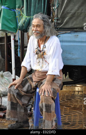 Thai Mann sitzt auf einem Hocker. Stockfoto