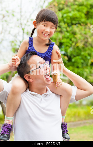 glückliche kleine Mädchen essen Eis mit Vater Stockfoto