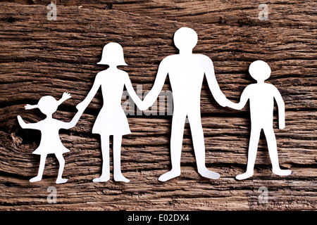 Pappfiguren der Familie auf einem Holztisch. Das Symbol der Einheit und des Glücks. Stockfoto