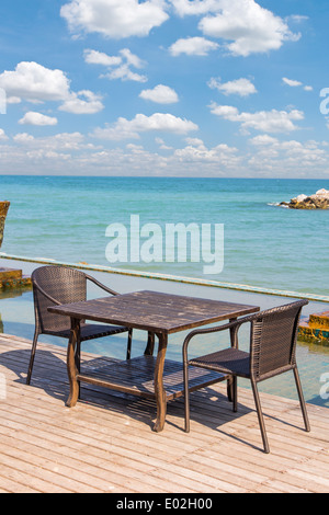 Tisch Stuhl neben Meer landschaftlichen Hintergrund Stockfoto