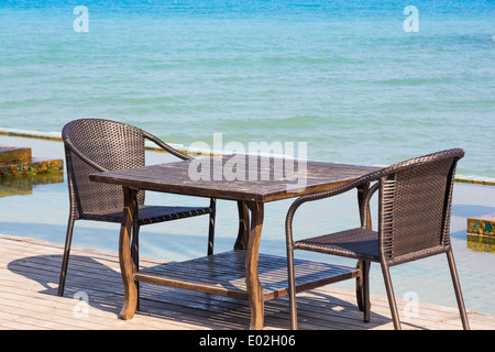 Tisch Stuhl neben Meer landschaftlichen Hintergrund Stockfoto