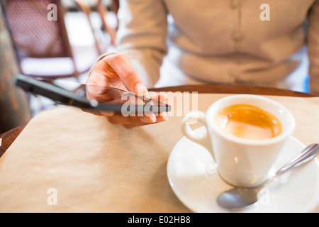 Weibliche Smartphone Kaffeebar Sms mail Stockfoto