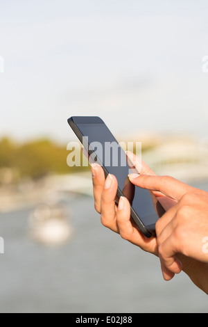 Weibliche Nahaufnahme von Händen Handy Hausboot Seine Brücke Nachricht Sms per e-mail Stockfoto