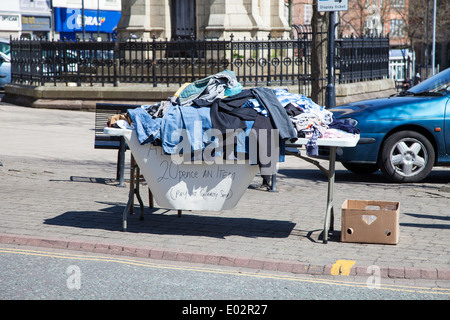 Ein Haufen von Kleidung aus zweiter Hand zum Verkauf außerhalb einer Charity-shop Stockfoto