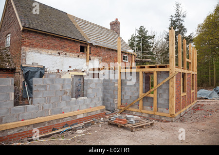 Ein Fachwerk Erweiterung einer bestehenden Ziegelbau Haus oder Häuschen im Bau oder gebaut Stockfoto
