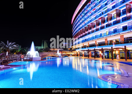 Das Schwimmbad und die Gebäude des Luxushotels in Nachtbeleuchtung, Antalya, Türkei Stockfoto