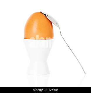 gekochte Brown egg Cup auf einem Ständer mit einem Löffel, isoliert auf weiss Stockfoto