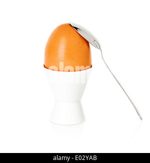 gekochte Brown egg Cup auf einem Ständer mit einem Löffel, isoliert auf weiss Stockfoto