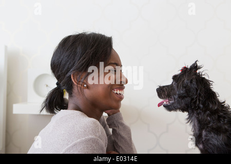 Ein junges Mädchen spielt mit ihren kleinen schwarzen Hund. Stockfoto