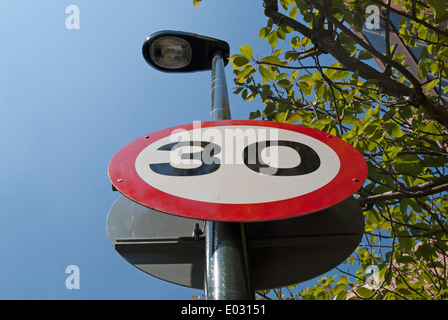 britische 30 km/h Höchstgeschwindigkeit Zeichen an einen Laternenpfahl befestigt Stockfoto