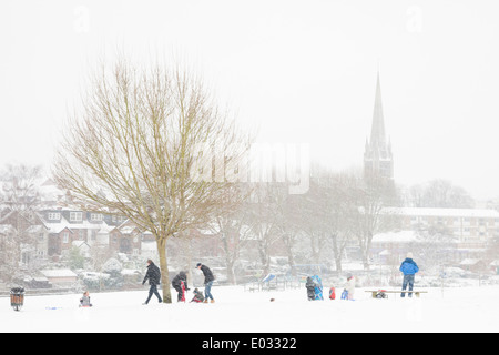 SURREY, UK-Eltern und Kinder trotzen Sie den Elementen, in Meadowbank Spielgelände, Dorking Rodeln gehen. Stockfoto