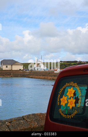 Isle of Scilly Blumen Logo auf dem Fenster mit RMV Scillonian III in der Ferne an Hugh Town, St Marys, Isles of Scilly, Scillies, Cornwall Stockfoto