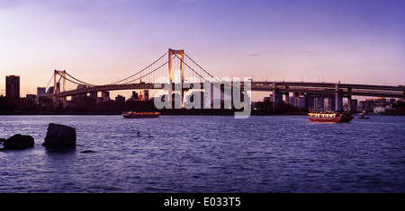 Panoramablick über die Regenbogenbrücke in Tokyo Bay bei Sonnenuntergang. Odaiba, Tokio, Japan. Stockfoto