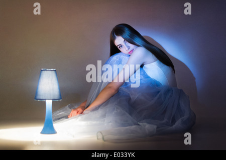 Schöne junge Ballerina in blau lange Tutu saß neben Lampe Stockfoto