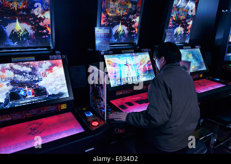 Person zu spielen Spielautomaten Lord of Vermilion Karte Arcade-Spiel in Tokio, Japan Stockfoto