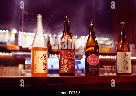 Mehreren japanischer Sake Flaschen, ume und Yuzu alkoholische Getränke an einer Bar Theke. Tokio, Japan. Stockfoto