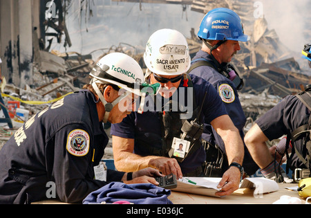 Urban Search and Rescue Teams gehen über ihre Suchraster bei Rettungseinsätzen in der Nachmahd des folgenden Zerstörung World Trade Center, die eine massive Terroranschlag die Twin zusammengebrochen Türme 2.606 Tötungleute 16. September 2001 in New York, NY. Stockfoto