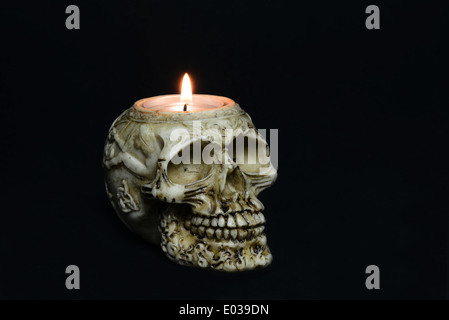 gruselige Totenkopf Kerze auf schwarzem Hintergrund - halbe Drehung Stockfoto