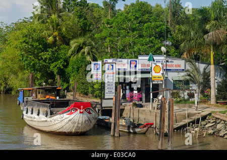 Boot an Tankstelle am Ufer des Flusses Mekong-Delta, Vietnam Stockfoto