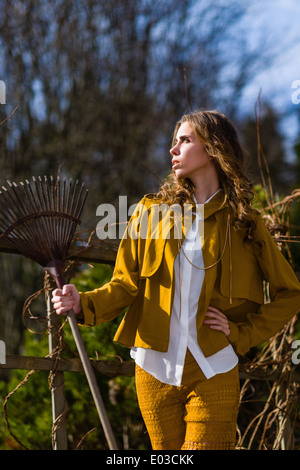 Schöne modische Frau und Rechen im Garten, Frühling Stockfoto