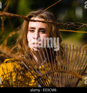 Schöne modische Frau und Rechen im Garten, Frühling Stockfoto