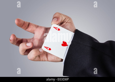 ein eleganter junger Geschäftsmann, Kartentricks mit Pokerkarten Stockfoto