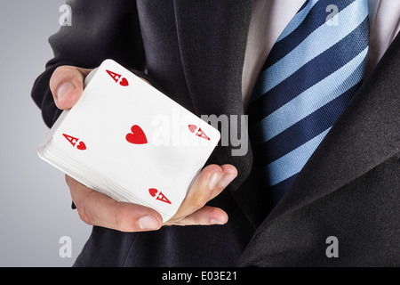 ein eleganter junger Geschäftsmann zeigt ein Ass in der hand Stockfoto