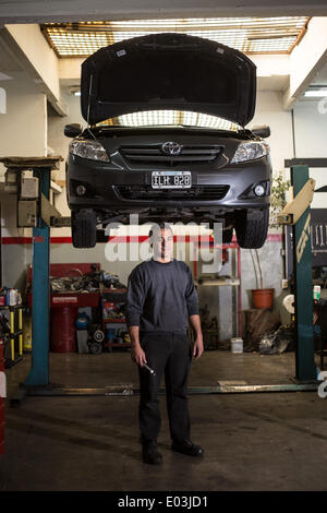 Buenos Aires. 28. April 2014. Bild aufgenommen am 28. April 2014 zeigt 39-j hrige Carlos Gonzalez posiert in seine mechanische Werkstatt in Buenos Aires, Argentinien. Carlos ist ein Mechaniker von Automobilen. Er dachte, sein Gehalt für den Job fair war. International Labor Day ist ein gesetzlicher Feiertag in Argentinien. Werke aus verschiedenen profes und Gewerbe kann einen Tag Pause vom anstrengenden Arbeitstag dauern. © Martin Zabala/Xinhua/Alamy Live-Nachrichten Stockfoto