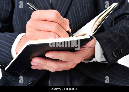 Nahaufnahme eines Geschäftsmannes in ein Notizbuch schreiben Stockfoto