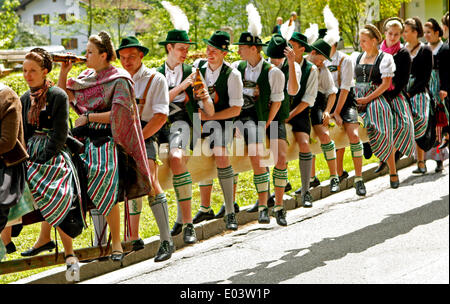 Siegsdorf, Deutschland. 1. Mai 2014. Jungen und Mädchen, die bayerische Tracht tragen sitzen auf einem Mai Pole, die auf dem Weg zur Eisenaerzt in der Nähe von Siegsdorf, Deutschland, 1. Mai 2014 aufzustellen ist. Foto: DIETHER ENDLICHER / Dpa/Alamy Live-Nachrichten Stockfoto