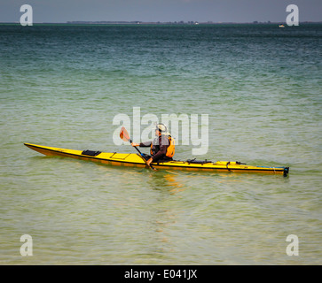 Ein Mann Kajaks solo entlang der Küste in der Nähe von Anna Maria Island, FL, im Golf von Mexiko. Stockfoto