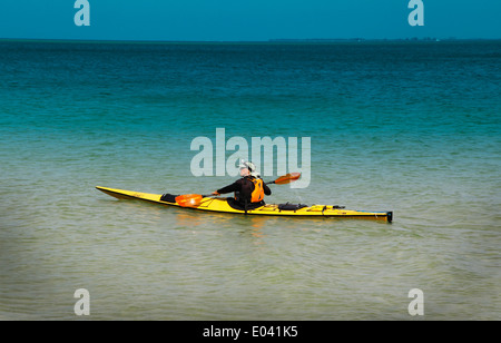 Ein Mann Kajaks solo entlang der Küste in der Nähe von Anna Maria Island, FL, im Golf von Mexiko. Stockfoto