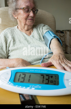 Ältere Dame in ihre neunziger Jahre, die zu Hause Blutdruck ckecked Stockfoto