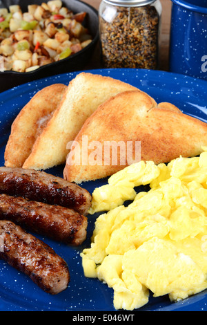 Nahaufnahme von einem Rührei-Frühstück mit Würstchen, Toast und Hash Brown Kartoffeln. Stockfoto