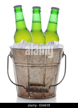 Ein altmodische Eimer gefüllt mit Eis und Bierflaschen. Drei grüne Flaschen Bier werden im Hochformat dargestellt. Stockfoto