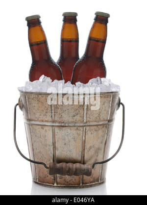 Ein altmodische Eimer gefüllt mit Eis und Bierflaschen. Im Hochformat sind drei braune Flaschen Bier vertreten. Stockfoto