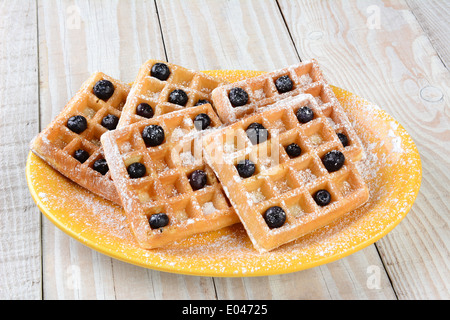 Nahaufnahme einer Platte von Waffeln und Heidelbeeren. Die Platte ist auf einem rustikalen Bauernhaus Stil Tisch. Stockfoto