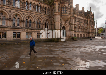 Man Walking in der ruhigen Fußgängerzone, in feuchten Pflaster von Centenary Square, Vergangenheit Bradford City Hall des Büros - West Yorkshire, England, Großbritannien Stockfoto