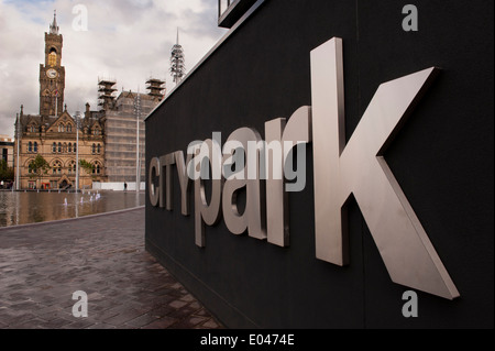 Urbane Landschaft in der Nähe von Bradford City Park Schild - Große geschwungene Spiegel Pool, die Stadt Halle und seine beeindruckenden Turm darüber hinaus. West Yorkshire, England, UK. Stockfoto