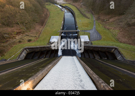 Ansicht von oben von hohen, steilen, Beton Damm am Thruscross Behälter Wasser Kanal an der Basis der Struktur - North Yorkshire, England, Großbritannien fließt. Stockfoto