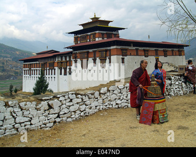 Ein Anbieter auf dem Tsechu Festival in Paro mit Paro Dzong im Hintergrund, Bhutan Stockfoto