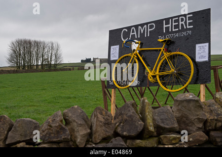 Aufmerksamkeitsstarke Werbung & gelb Bike im Feld, auf der Route der "Grand abzuweichen", um Pop-up-Werbung Campingplatz - Skipton, North Yorkshire, England, UK. Stockfoto