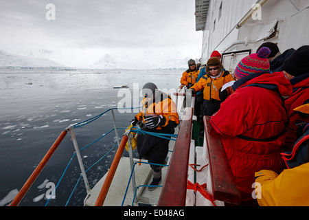 Passagiere an Bord eines Schiffes zu Fuß hinunter Gangway zu Zodiacs auf Antarktis Kreuzfahrt Stockfoto