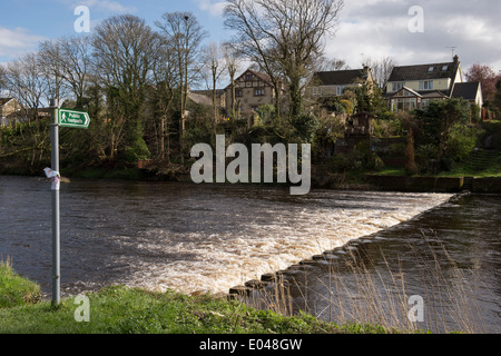 Öffentlichen Fußweg Zeichen, zu teilweise überdachte Trittsteine Kreuzung fließenden Fluss-River Wharfe in der Nähe von Skipton, West Yorkshire, England, UK. Stockfoto